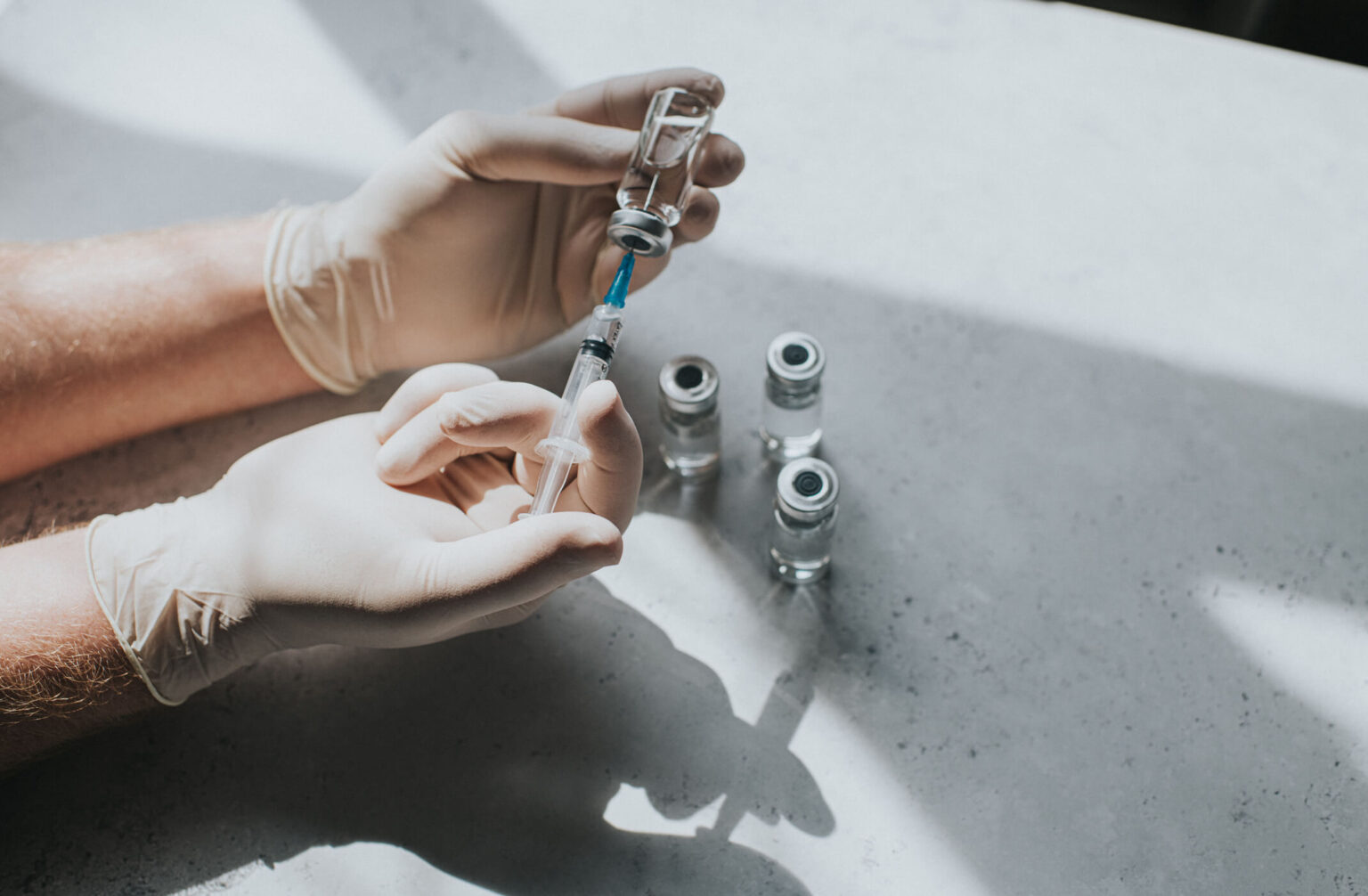 Utilisations cliniques de la toxine botulique syringe-vials-person-holding-needle-wearing-gloves