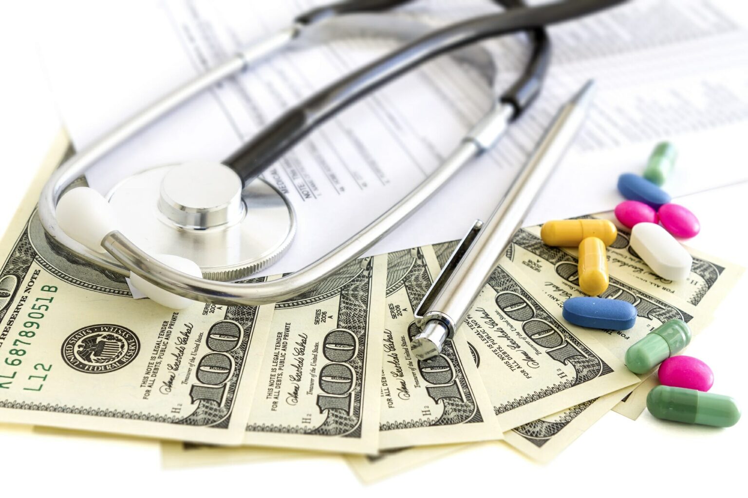 Money, stethoscope, and pills