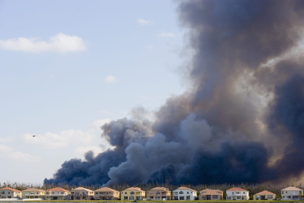 Helicopter-near-smoke-caused-by-brush-fire-behind-houses