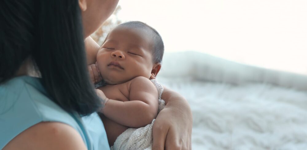 Surmonter les défis en tant que médecin et nouveau parent Mother-holds-an-infant-in-her-arm,-newborn-baby-at-home