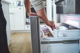 Personne qui regarde son congélateur