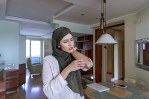 Une femme se grattant la main